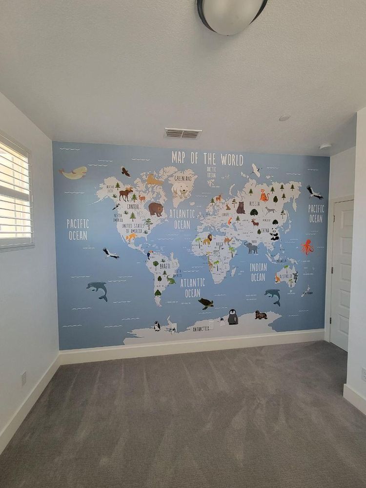 Children's room with a soft blue world-map mural feature wall