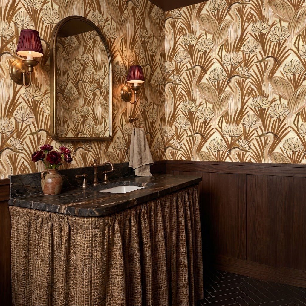 Moody powder room with heron-motif wallpaper, marble top, and walnut vanity
